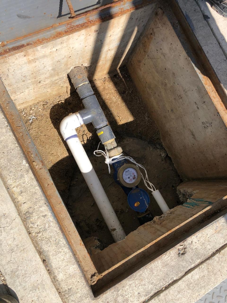 Medidor de agua potable instalado dentro de un registro subterráneo de concreto con tuberías de PVC en proyecto re reingeniería de sistema hidrico en tijuana